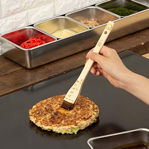 Tare fırçasıyla teppan üzerindeki okonomiyaki ye sos sürülürken